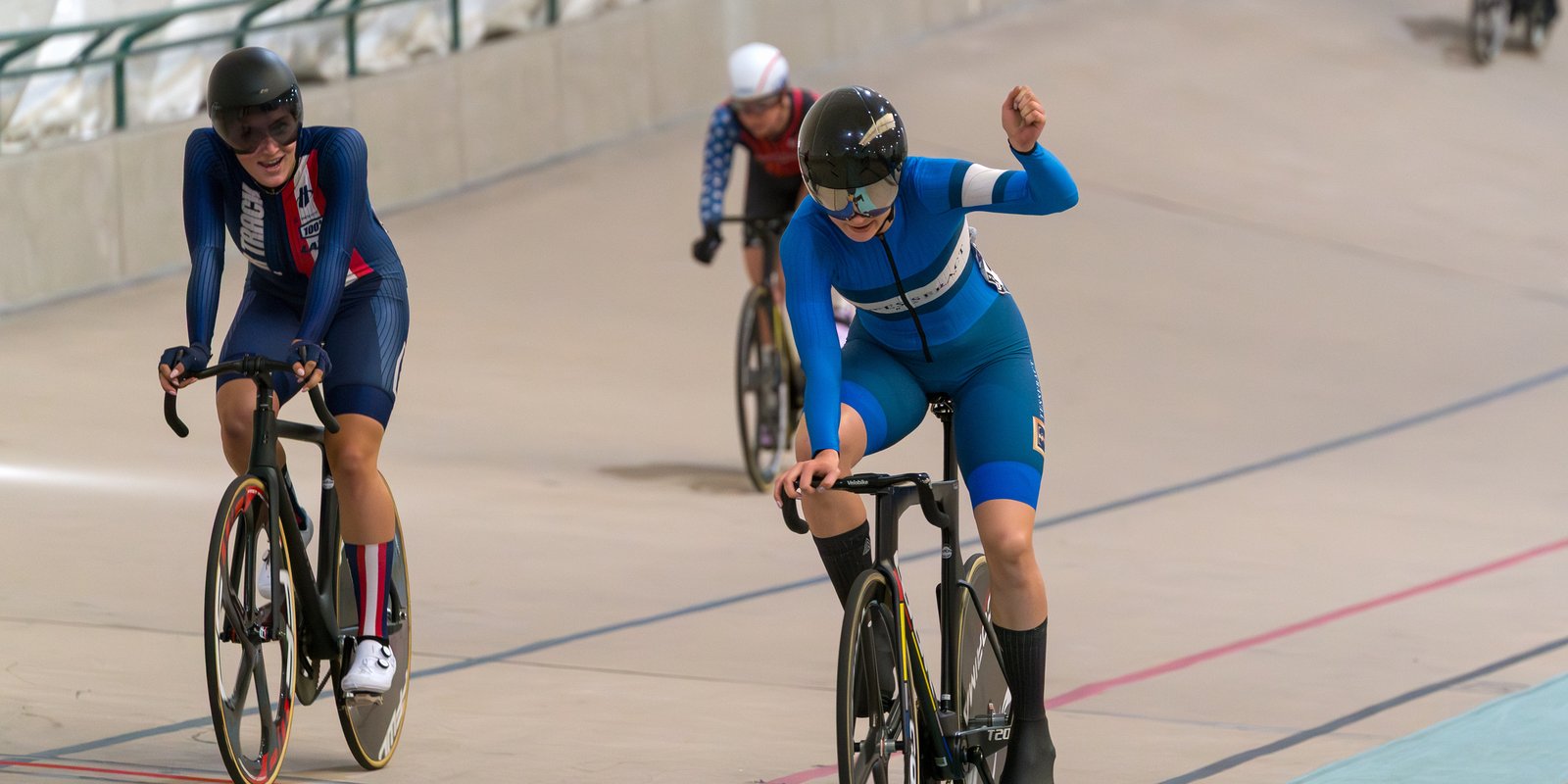 M celebrates her win in the USAC Elite Keirin championships 2025, with an upraised arm, rolling over the finish line
